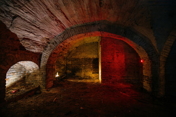 Fototapeta premium Dark and creepy vaulted red brick cellar under old castle