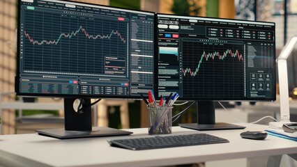 Trading software in prop firm office with price graphs and technical indicators visible on screens. Desktop setup for financial experts tracking stock market activity using analytical tools © DC Studio