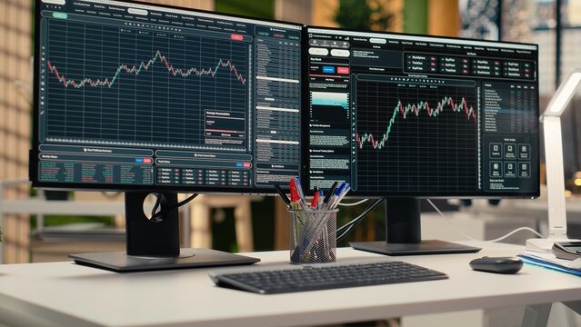 Trading software in prop firm office with price graphs and technical indicators visible on screens. Desktop setup for financial experts tracking stock market activity using analytical tools