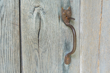 Close-up of an old, weathered wooden door with rusted metal latch in an ancient Central European...