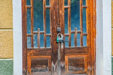 Close-up of an aged wooden door in a Central European village, with rust stains and vertical grain. a