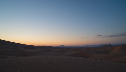 Fototapeta premium The vast desert landscape is bathed in the soft, warm hues of a setting sun, with rolling sand dunes stretching towards a clear, gradient sky