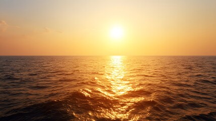 A breathtaking sunset paints the vast ocean with warm golden hues, casting a tranquil glow over the rippling waves.