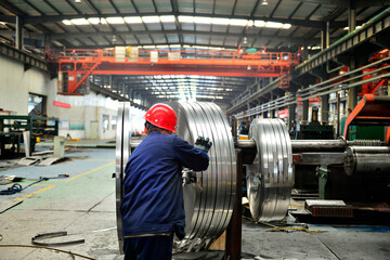Workers on the production line of the strip steel coil factory are working