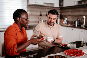 Couple enjoying a meal together in a cozy kitchen during dinner time
