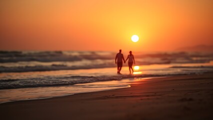 Obraz premium Sunset at the beach with golden light and distant silhouettes of a family.