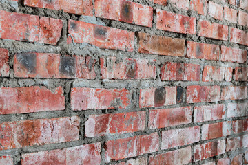 Close-up of an old red brick wall with rough mortar. Rustic and weathered texture suitable for...