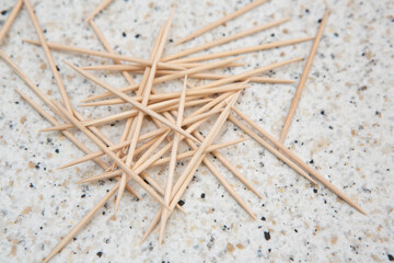 toothpicks lie scattered on a speckled table