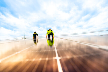 A solar energy engineer coordinates a project on the phone while on a rooftop solar installation. A...
