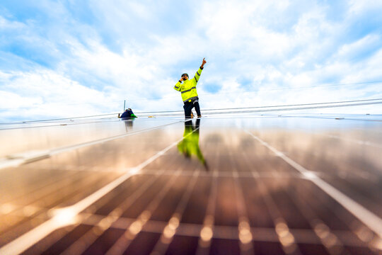 close up on grid of technology renewable solar energy. construction solar panels system on roof. Installing solar photovoltaic panel system. background of blue of solar cell system and structure roof.