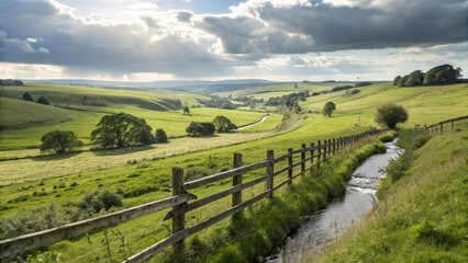 Obraz premium Weathered wooden fence stretching along lush green fields on rolling hill countryside farm, under cloudy blue sky with amazing sunlit rays effects