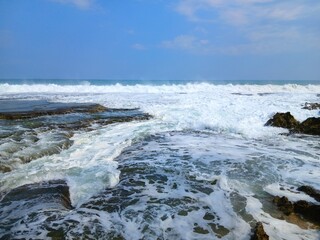 Capture the essence of nature with this stunning image of crashing waves on a rocky beach. A perfect fit for outdoor adventures and coastal explorations.