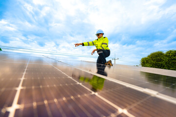 A technician in safety gear inspects solar panels on a metal rooftop, holding a tool. The scene...