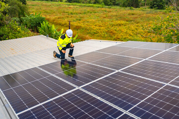 A confident engineer smiles and points at the camera while working on a rooftop solar panel...