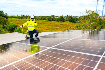 engineer man inspects construction of solar cell panel or photovoltaic cell by electronic device....