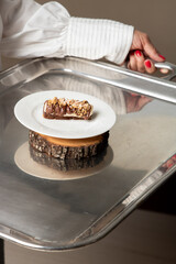 Waiter Presenting Nougat and Chocolate Dessert on Silver Platter