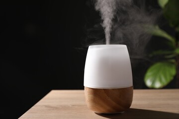 Modern aroma lamp on wooden table indoors