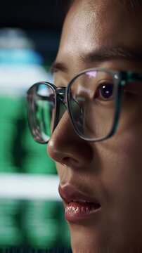 Close-Up View: Woman in Glasses Focuses on Green Code, Intense Concentration, Digital World Exploration, Nighttime Setting.