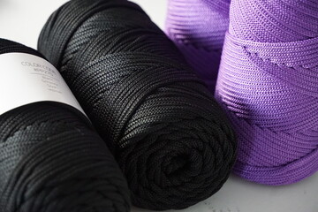 Close-up of black and purple yarn skeins for knitting and crochet crafts.