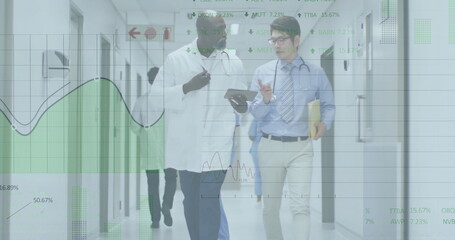Walking two doctors in lab coat and tie along hospital corridor, reviewing tablet data overlays