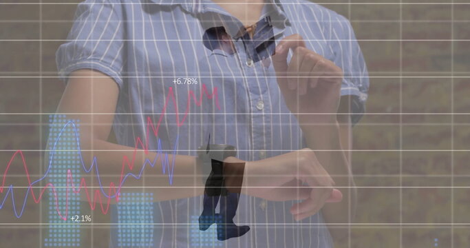 Adjusting man tapping smartwatch interface at office, showing holographic line and bar graphs