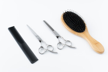 白背景にヘアブラシと散髪用のはさみとすきばさみと櫛のセット