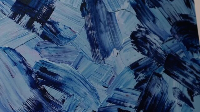 Artistic creation using blue acrylic paint with rough brushwork on stretched canvas surface