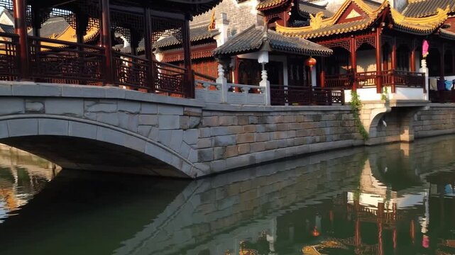 Peaceful Traditional Village by River Featuring Golden Pavilion on Bridge
