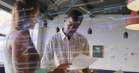 female colleague holding report pointing at charts urging male scanning business data for insight - Powered by Adobe