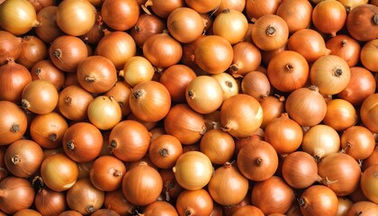 A dense collection of small, uniformly-sized, light-brown onions fills the frame