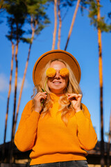 Woman faceless yellow sweater closing eyes with orange dahlia into camera Autumn Fall Bouquet for...