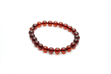 Amber bracelet isolated on white background. Red cherry amber from Myanmar, rosary