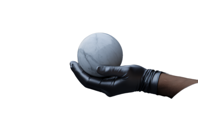 A marble sphere held in a gloved hand with rocky landscape in the background