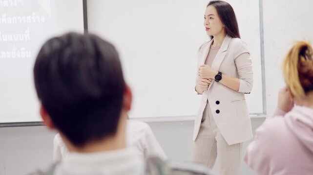 Asian business executive woman speaking during company workshop or business meeting, engaging team with confident body language and ideas.