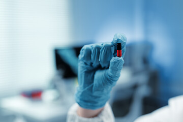 Close up of scientist hand holding a red and black pill in a laboratory setting, conducting...