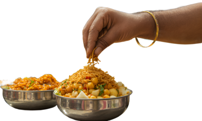 Hand garnishing a dish of street food