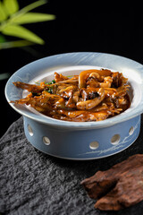 A delicious stir-fried dish featuring shrimp and mushrooms served in a ceramic bowl, showcasing savory and appetizing cuisine.