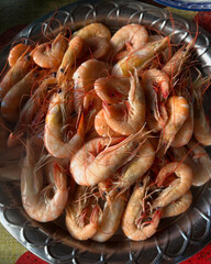 Orange shrimp served in silver round tray.