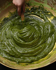Bright green paste swirls smoothly in bowl.