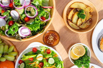 Healthy food  with organic vegetables salad, fried potato and fresh fruit on dining table. Happy family enjoy weekend activities celebration meeting party having dinner eating food together at home.