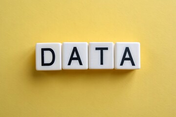Four white letter tiles spelling out the word DATA arranged in a line on a bright yellow background