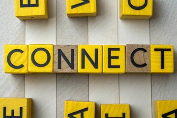 Yellow and wooden blocks spelling the word CONECT arranged in a line with scattered blocks connect