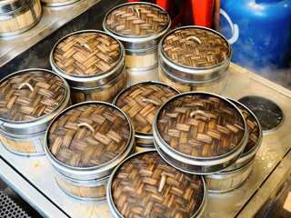 Traditional Dim Sum Bamboo Steamers at Street Food Stall. popular in Chinese food culture and night markets. Perfect for concepts of traditional cooking, dim sum dining, Asian street food.