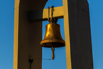 Obraz premium Bronze bell framed by architecture against a vibrant blue sky. Evokes history, religion, and tradition in Brazil