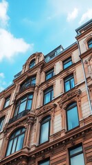 Fototapeta premium Ornate, light beige building facade, many arched windows, against a partly cloudy sky