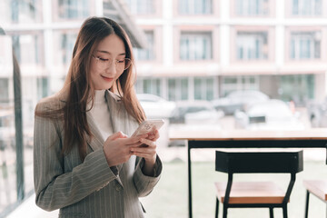 Obraz premium Engaging professional woman using smartphone at modern office space indoor setting casual viewpoint technology focus