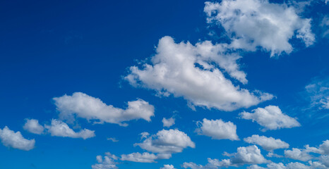 Sky view. Beautiful sunny sky. Background with clouds on blue sky. Clouds on blue sky. Sun shining through the puffy clouds.