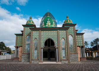 Ornate Mosque with Green Domes and Intricate Gold Geometric Patterns under Blue Sky