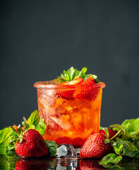 Fresh summer cocktail with strawberry and ice. Strawberry soda drink on the rustic background....