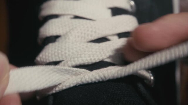 The act of tying shoelaces on sneakers, as depicted in the top view, symbolizes readiness and preparation.
